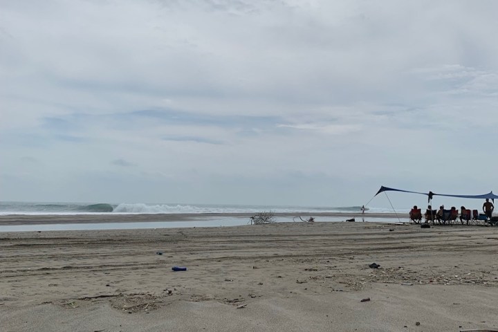 a group of people standing on top of a sandy beach
