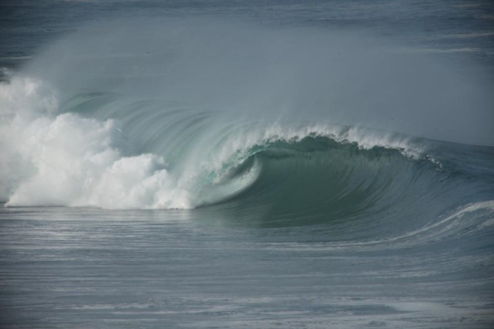 a man riding a wave on a surfboard in the water